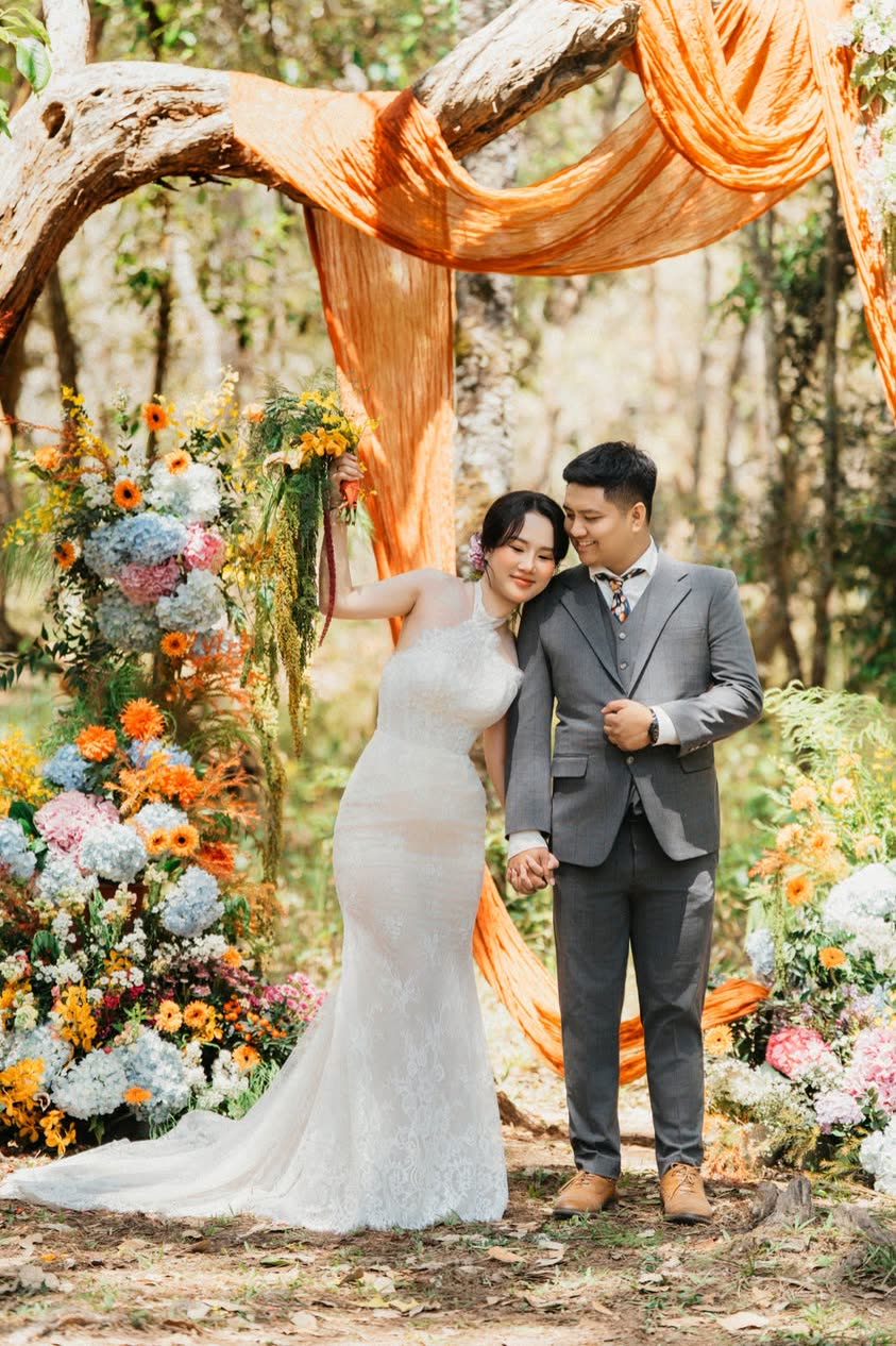 Cô dâu chú rể dưới cổng hoa và vải cam giữa rừng